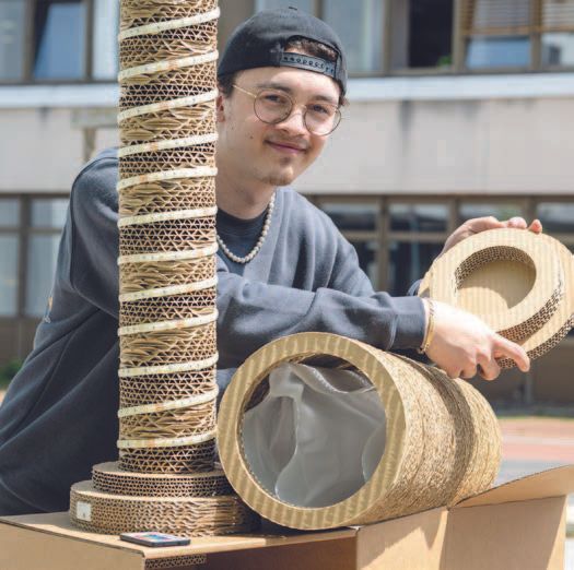 John Koch (Mitte) erhielt den ersten Preis für eine Lichtsäule, um die sich bunte LED-Leuchten schlängeln. Dem gerundeten Pappkörper hat er zusätzlich gelochte Pappe übergestülpt.