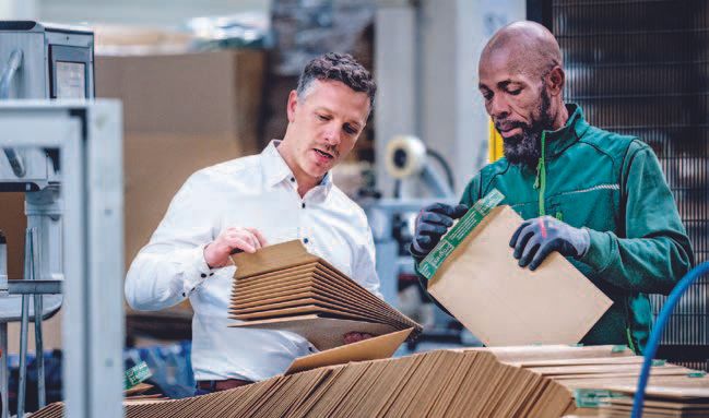 Qualitätsprüfung: Produktionsleiter Thomas Zavaczki (links) und Mitarbeiter Koffi Akue begutachten Verpackungen mit Selbstklebeverschluss und Aufreißfaden.