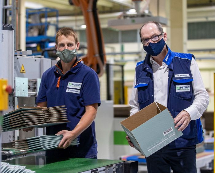 Geschäftsführer Winfried Flemmer (r.) und Mitarbeiter Ralf Hornemann an einer Maschine für Faltschachteln.